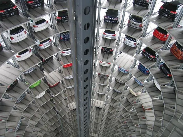 Vedere din interiorul unui parc auto modern cu mașini aranjate pe etaje.
