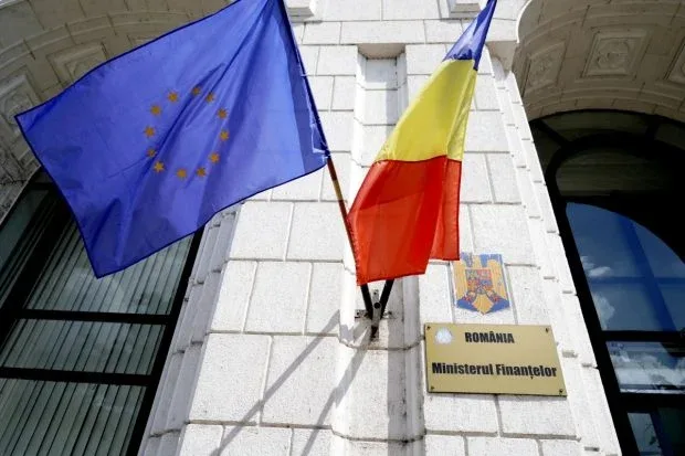 Clădirea Ministerului Finanțelor din România cu steagurile naționale și europene.