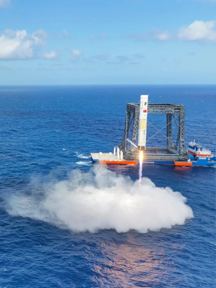 Racheta Long March-10 decolează de pe platforma maritimă, lăsând în urmă un nor de fum.