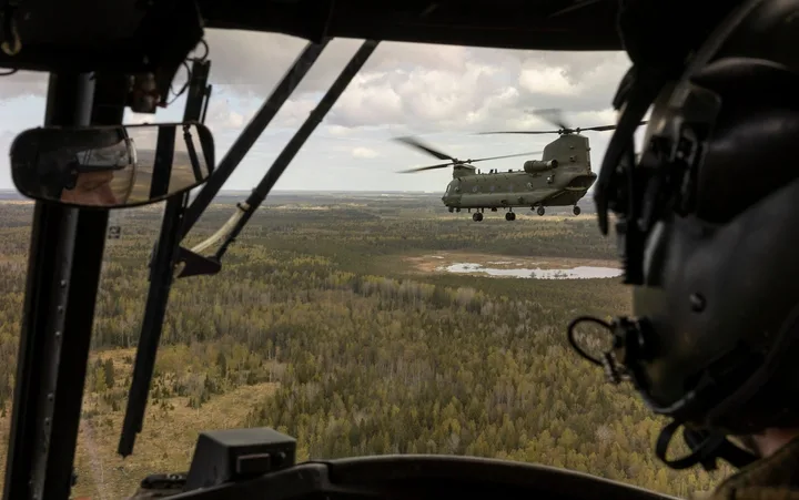 Un elicopter zboară deasupra unei păduri din Estonia, în timpul unui exercițiu militar.