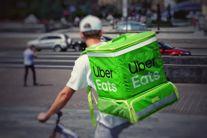 Un livrator Uber Eats se pregătește să facă o livrare în oraș.