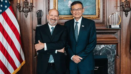 CEO-ul Lip-Bu Tan și un partener în fața drapelului american.