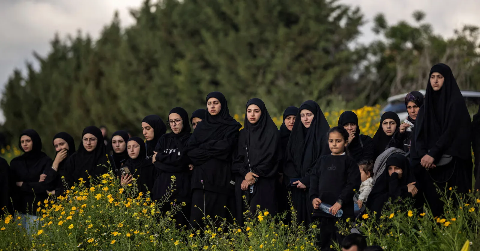 Grup de femei îmbrăcate în negru, în mijlocul naturii, reflectând asupra situației din Liban.