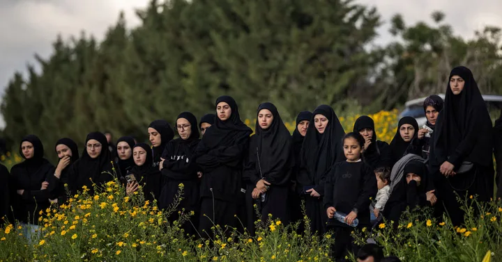 Grup de femei îmbrăcate în negru, în mijlocul naturii, reflectând asupra situației din Liban.