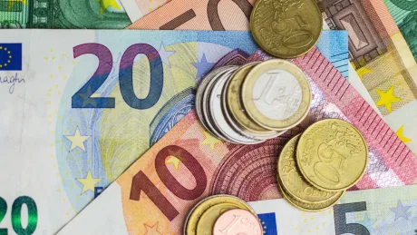 Bancnote și monede euro, simbolizând salariul minim în Uniunea Europeană.