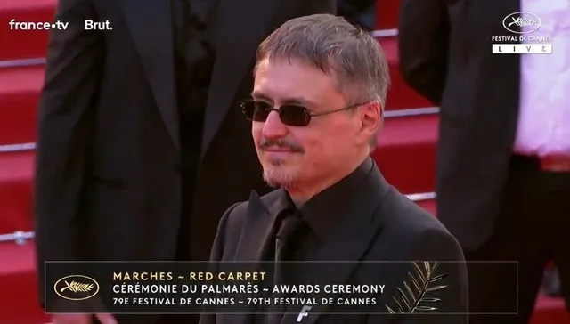 Cristian Mungiu pe covorul roșu la Cannes, discutând despre finanțarea cinematografiei românești.