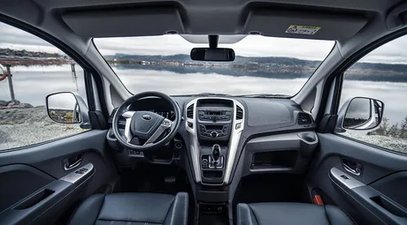 Interior modern al unui vehicul electric BYD, cu un peisaj natural în fundal.