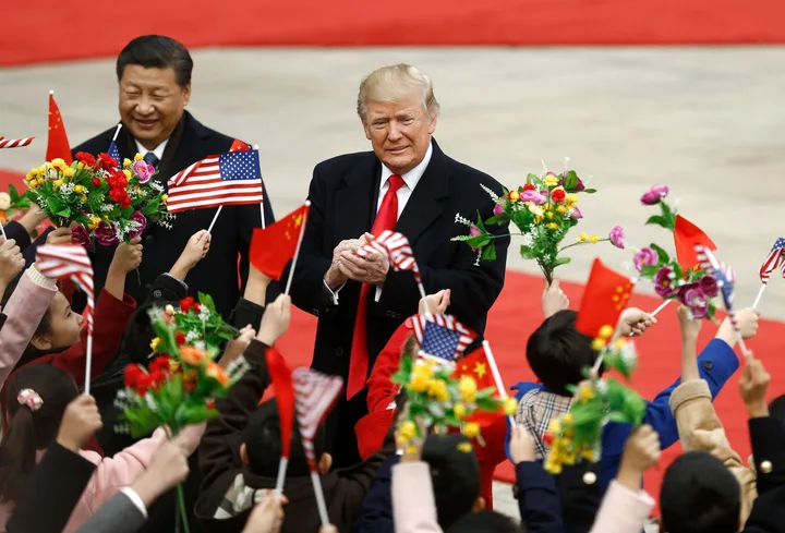 Donald Trump interacționează cu copii și oficiali în timpul unei vizite anterioare în China.