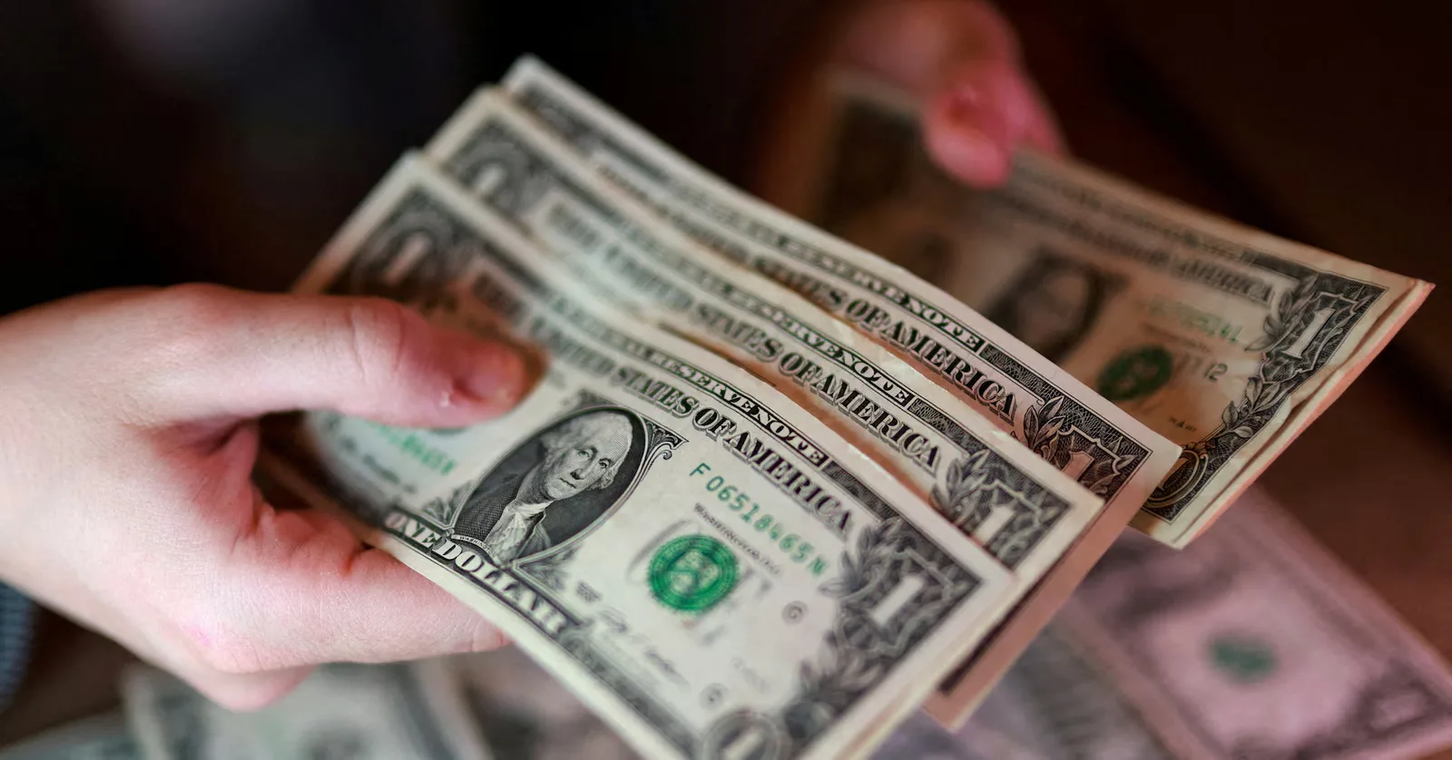 Bancnote de dolar american în mâinile unei persoane.