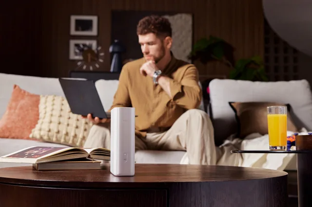 Utilizator lucrând pe laptop, cu TCL 5G CPE B50 în prim-plan.