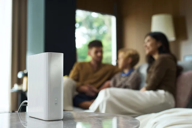 Familie relaxându-se în sufragerie, cu TCL 5G CPE B50 vizibil.