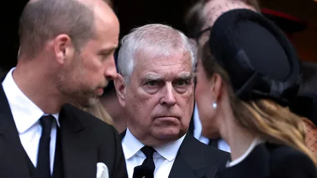 Prințul Andrew discutând cu alți membri ai familiei regale la un eveniment solemn.