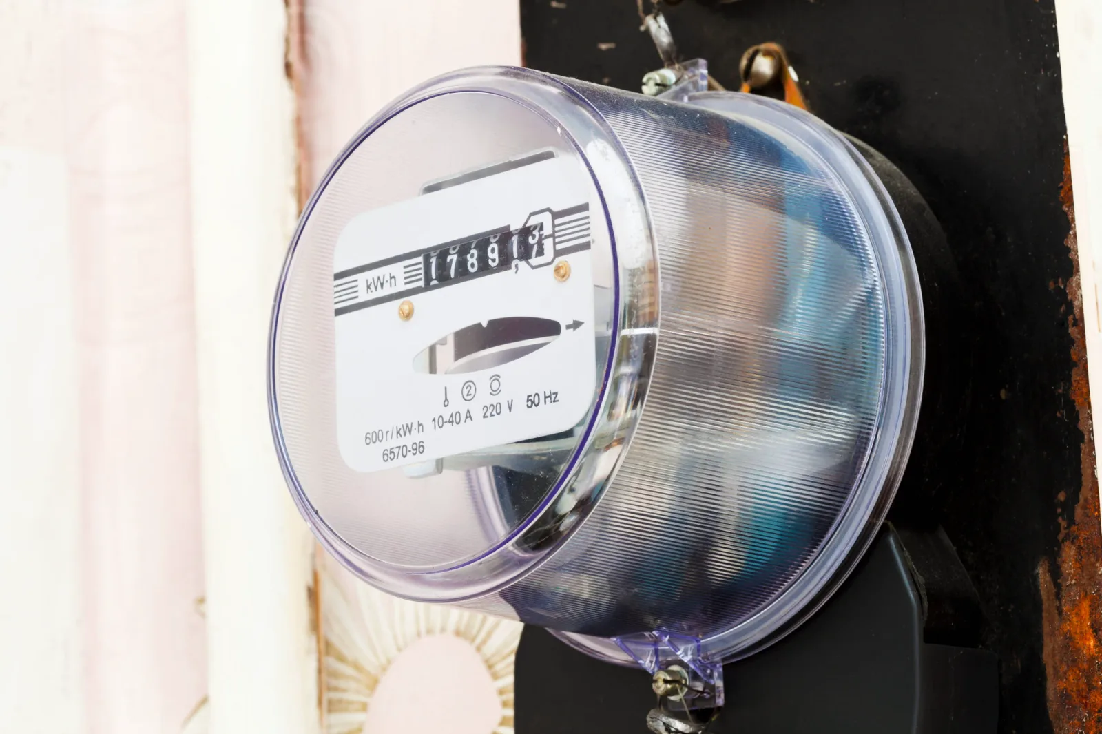 Contor de energie electrică montat pe un perete, cu cifre vizibile.