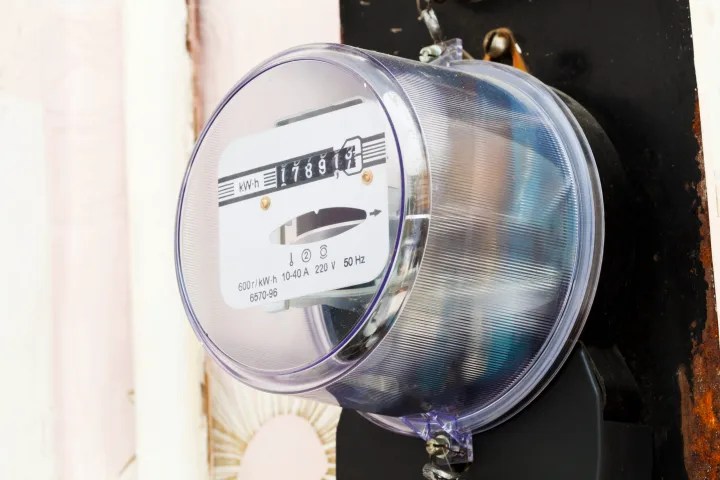 Contor de energie electrică montat pe un perete, cu cifre vizibile.