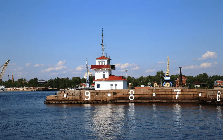 Far și port în Golful Finlandei, cu ape calme și cer senin.