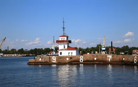 Far și port în Golful Finlandei, cu ape calme și cer senin.