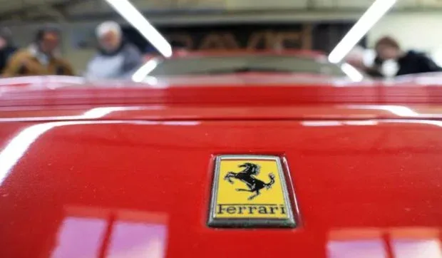 Logo Ferrari pe un automobil roșu, simbol al luxului și evaziunii fiscale.