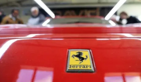 Logo Ferrari pe un automobil roșu, simbol al luxului și evaziunii fiscale.