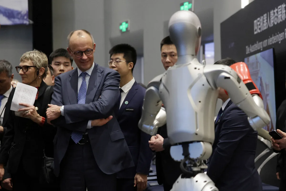 Friedrich Merz admirând un robot la o expoziție din Beijing.