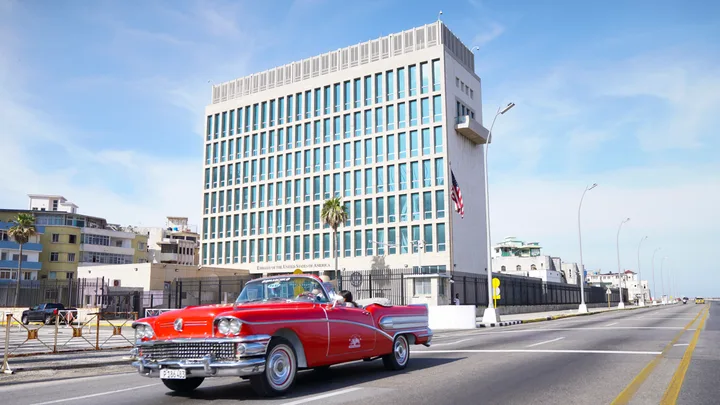 Ambasada SUA la Havana, cu un automobil clasic roșu în față.