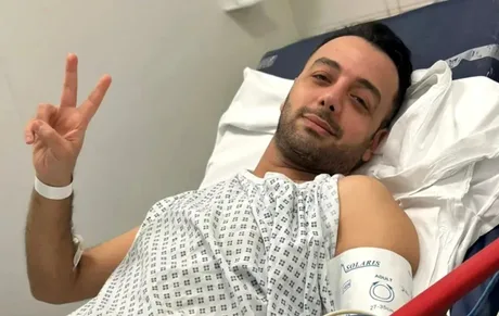 Jurnalistul iranian, recuperându-se după atacul cu cuțitul, zâmbind din spital.