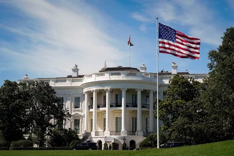 Casa Albă sub lumina soarelui, cu steagul SUA fluturând.