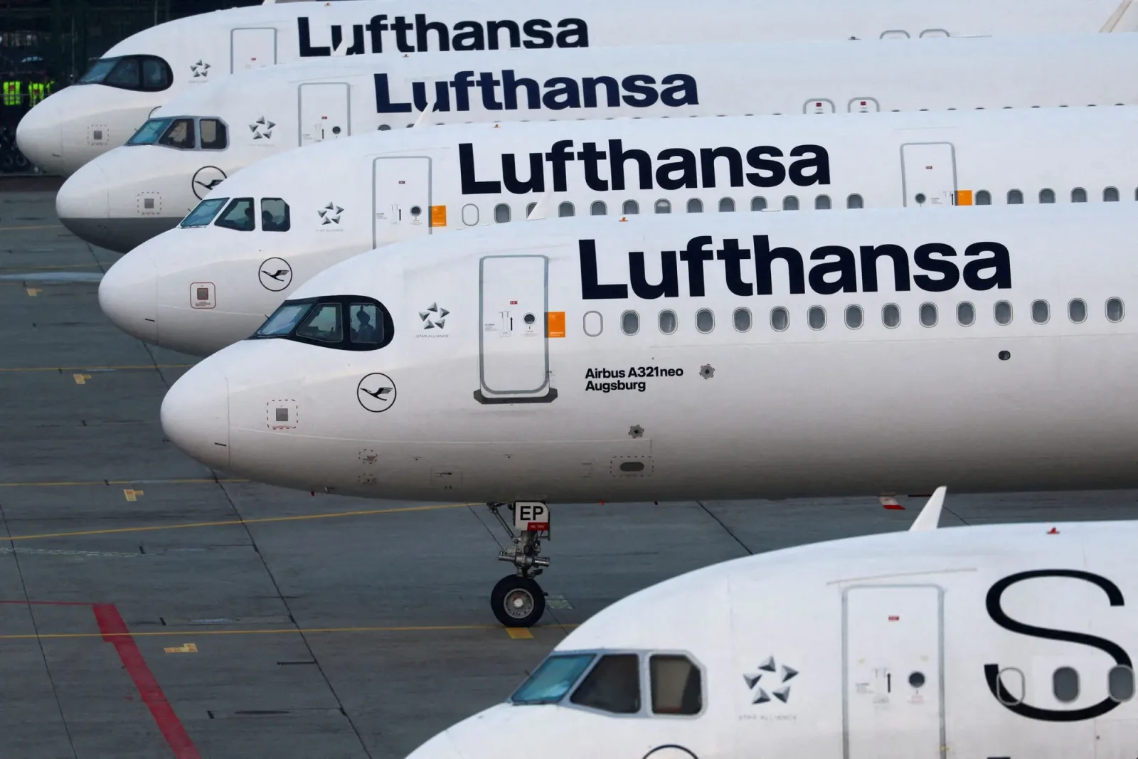 Avioane Lufthansa parcate pe aeroport, simbolizând schimbările tarifare.
