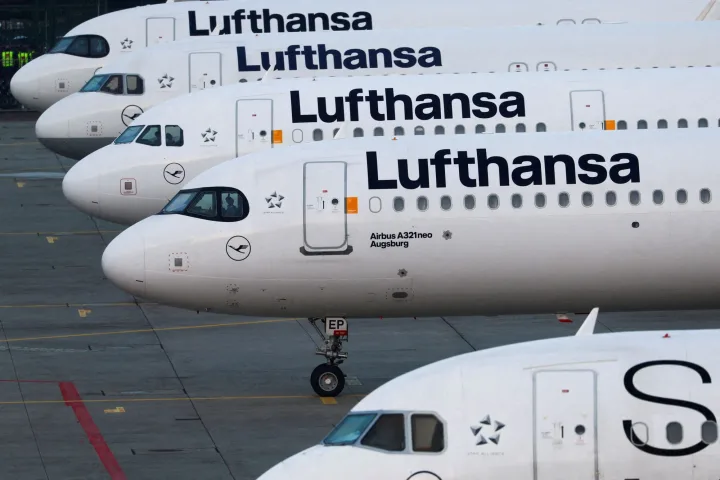 Avioane Lufthansa parcate pe aeroport, simbolizând schimbările tarifare.