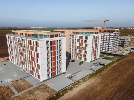 Blocuri de locuințe moderne în construcție, cu terenuri în jur.
