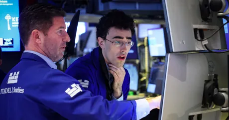 Investitori pe Wall Street discutând despre piețele financiare și perspectivele economice.