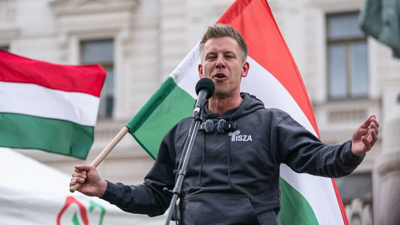 Péter Magyar vorbește la un miting cu steaguri ungurești în fundal.