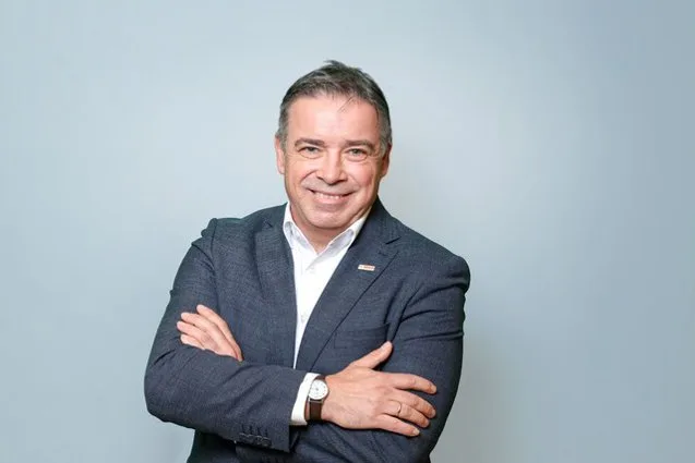 Reprezentant Bosch zâmbind, îmbrăcat în costum, cu brațele încrucișate.