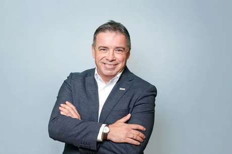 Reprezentant Bosch zâmbind, îmbrăcat în costum, cu brațele încrucișate.