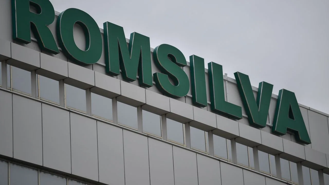 Clădirea Romsilva cu sigla verde pe fațadă, sub un cer noros.