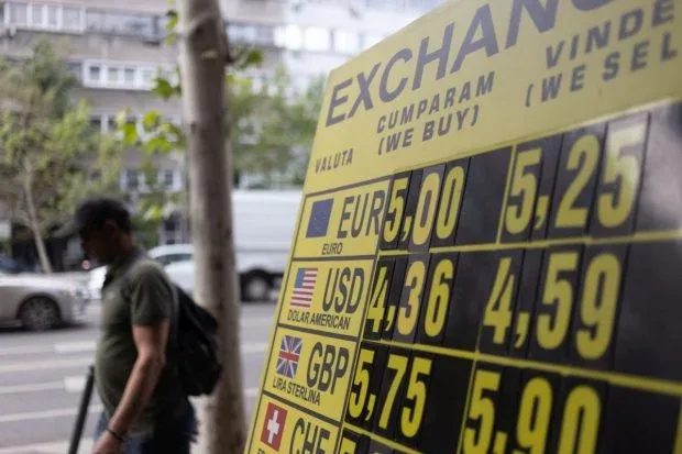 Curs valutar afișat pe un panou în oraș, cu valori pentru euro și dolari.