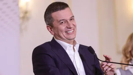 Sorin Grindeanu zâmbind la o conferință de presă.