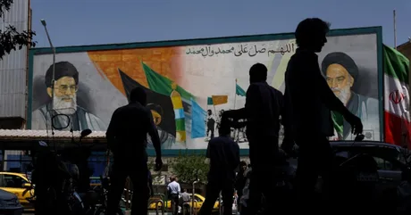 Oameni care trec pe lângă un mural în Teheran, Iran.
