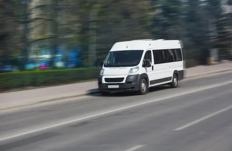 Microbuz electric în mișcare pe o stradă urbană, evidențiind achizițiile controversate.