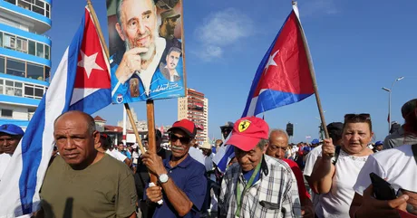 Oameni cu steaguri cubaneze participând la o manifestație în Havana.