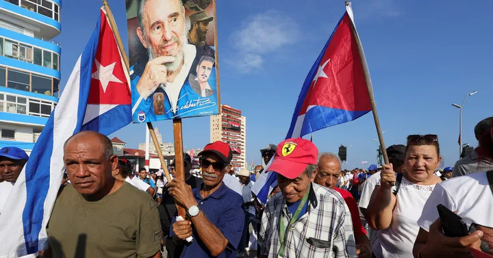 Oameni cu steaguri cubaneze participând la o manifestație în Havana.