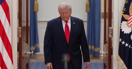 Donald Trump părăsește o cameră, având o expresie serioasă.