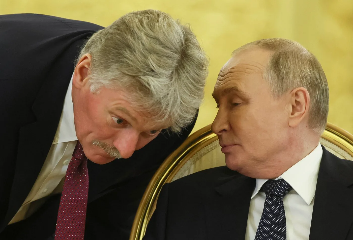 Dmitri Peskov discutând cu un oficial rus într-un cadru formal.