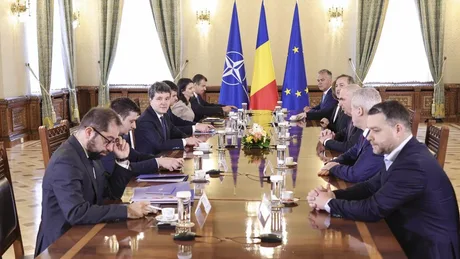 Ședință de cabinet cu miniștri interimari și steaguri naționale.
