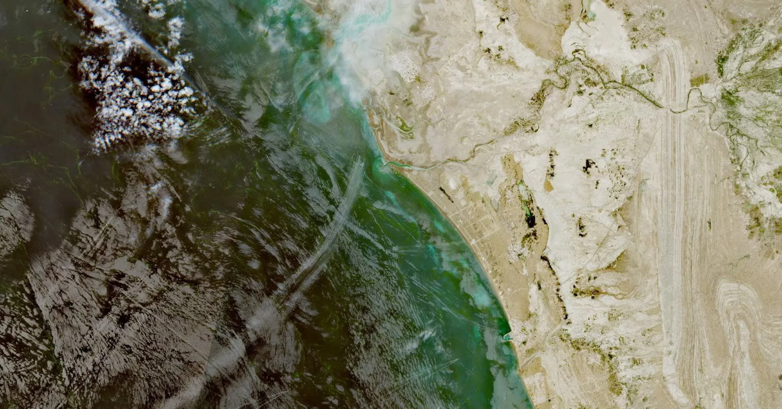 Vedere aeriană a Strâmtorii Hormuz, evidențiind peisajul maritim și terestru.