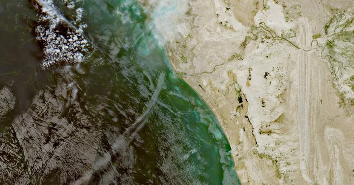 Vedere aeriană a Strâmtorii Hormuz, evidențiind peisajul maritim și terestru.