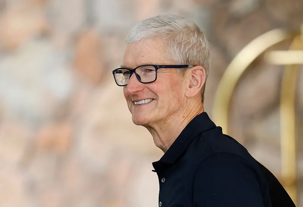 Tim Cook zâmbind, purtând ochelari inteligenți, într-un mediu relaxat.