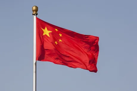 Steagul Chinei fluturând pe un fundal albastru senin.