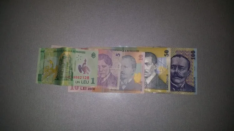 Bancnote românești de diferite valori așezate pe o suprafață plată.