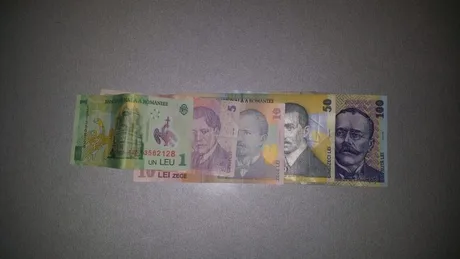 Bancnote românești de diferite valori așezate pe o suprafață plată.