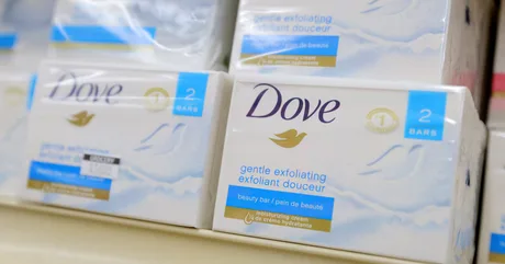 Produse Dove expuse pe raft, evidențiind brandul de frumusețe.